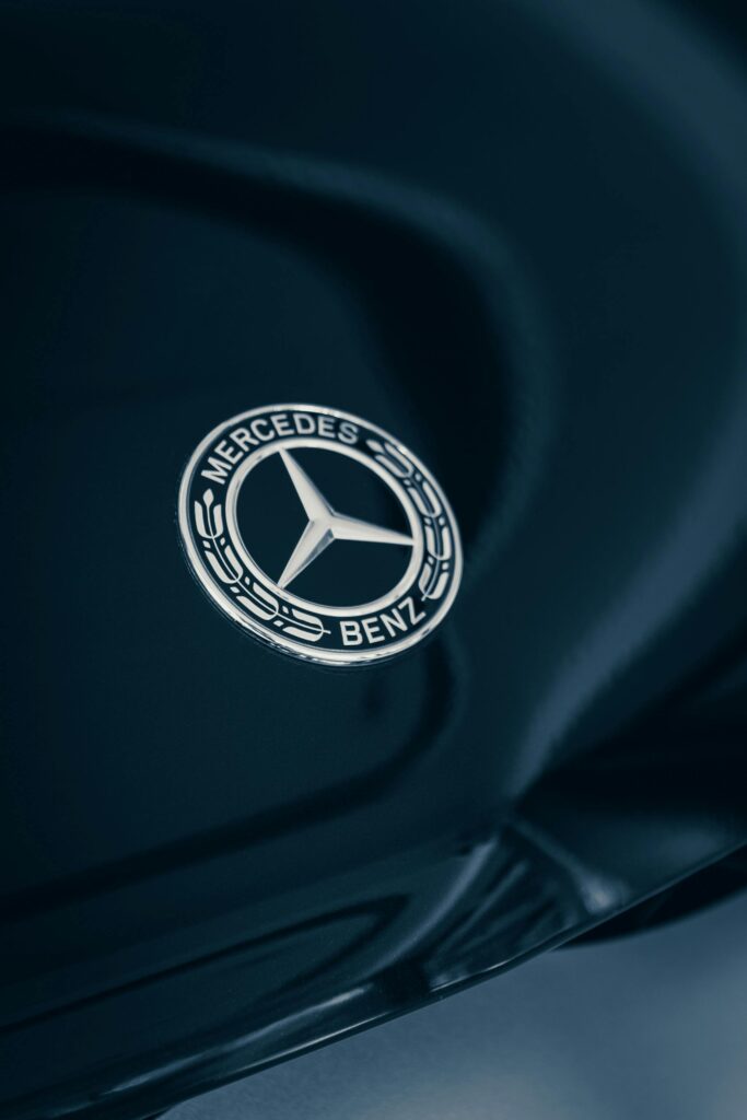 Detailed close-up of a Mercedes-Benz emblem with elegant reflections.